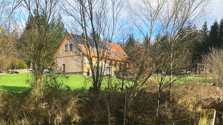 Das Forsthaus von außen, umgeben vom Wald